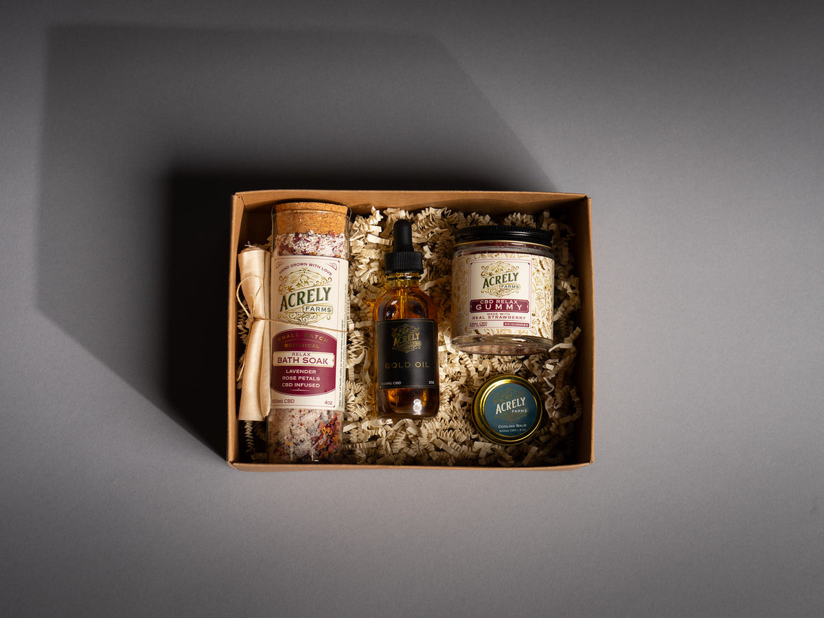 Gift set with Acrely products bath soak gold oil, relax gummies, and mini cooling balm.