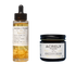 Two Acrely Farms products on a plain white background: a clear dropper bottle of Repair Oil with a black cap and a black jar of Recovery Balm with a white label.
