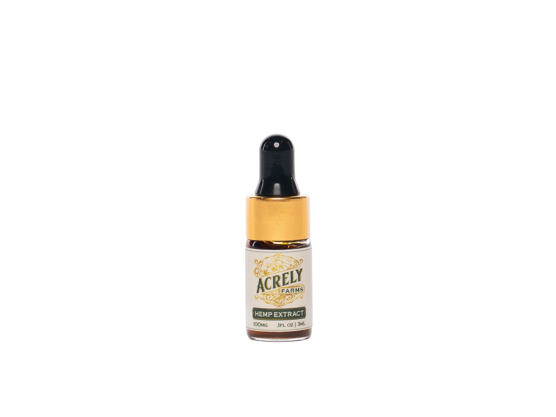A small amber glass dropper bottle labeled Acrely Farms Hemp Extract, featuring a black dropper cap and a cream label with gold accents, centered on a plain white background.