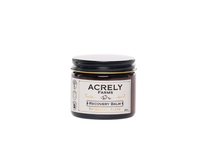 A small amber glass jar of Acrely Farms Recovery Balm with a black lid and a cream-colored label, set against a plain white background.