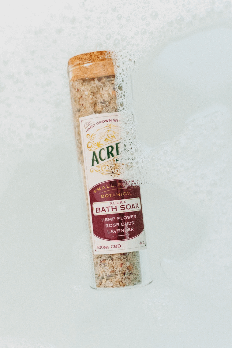 Acrely Farms Relax Bath Soak packaging in the bathtub of water.
