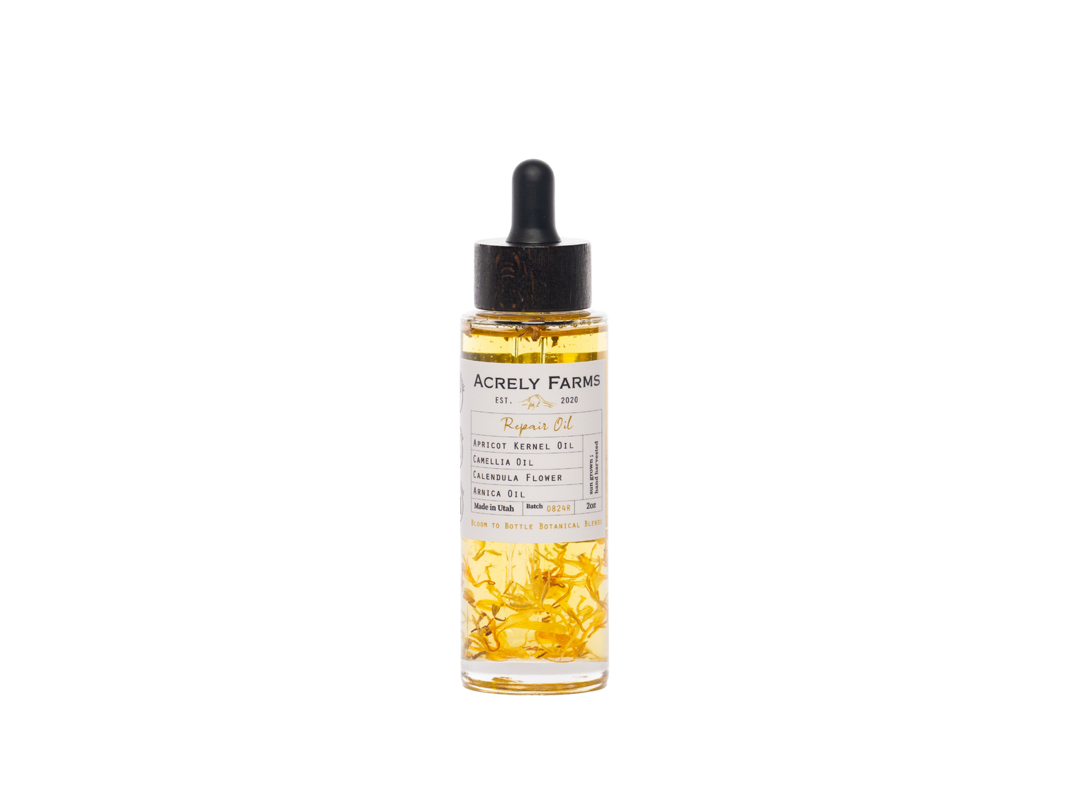 A clear glass dropper bottle of Acrely Farms Repair Oil with a black rubber dropper cap, filled with golden-yellow oil and containing visible dried yellow flower petals, set against a plain white background.